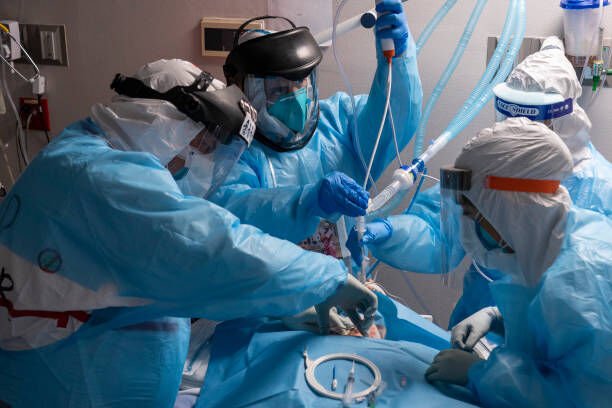 HOUSTON, TX - DECEMBER 14: (EDITORIAL USE ONLY) Dr. Joseph Varon, left, medical staff members Gabriel Cervera Rodriguez, second from left, Elizabeth Gamboa, third form left, and Stephanie, right, perform tracheostomy procedure on a patient in the COVID-19 intensive care unit (ICU) at the United Memorial Medical Center on December 14, 2020 in Houston, Texas. According to reports, Texas has reached over 1,480,000 cases, including over 24,500 deaths. (Photo by Go Nakamura/Getty Images)