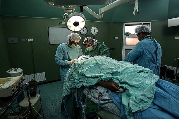 GAZA CITY, GAZA - JUNE 02: Muna Keskin (C), the only woman neurosurgeon of Gaza, performs surgery on a patient at the Al-Shifa Hospital in Gaza City, Gaza on June 2, 2015. (Photo by Ali Hassan/Anadolu Agency/Getty Images)