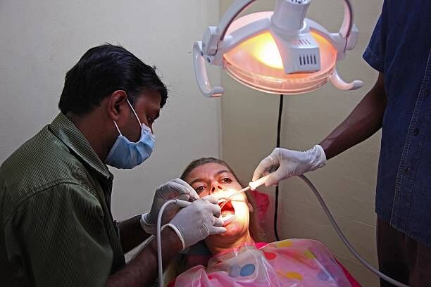 TRIVANDRUM, INDIA - JANUARY 09: Dentist Dr. Arun treats a female tourist in his dental spa clinic at Clafouti hotel in Varkala on January 09, 2010 in Varkala near Trivandrum, Kerala, India. Modern medical and dental treatment in India attracts many foreign tourists to save money. (Photo by EyesWideOpen/Getty Images)