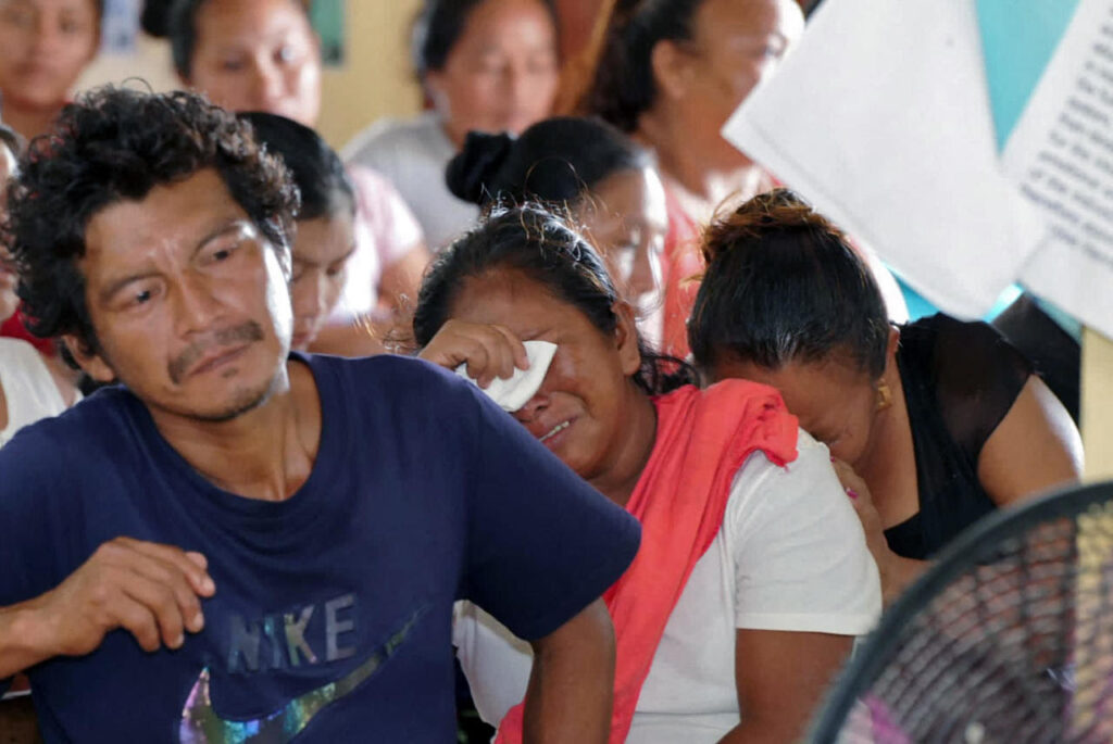 Relatives and friends of the victims of a fire on the eve that killed at least 19 youths and injured about 20 others in a schoolgirls' dormitory, cry during a meeting with Guyana's President Irfaan Ali, in Mahdia, Guyana, on May 22, 2023. (Photo by Keno GEORGE / AFP)