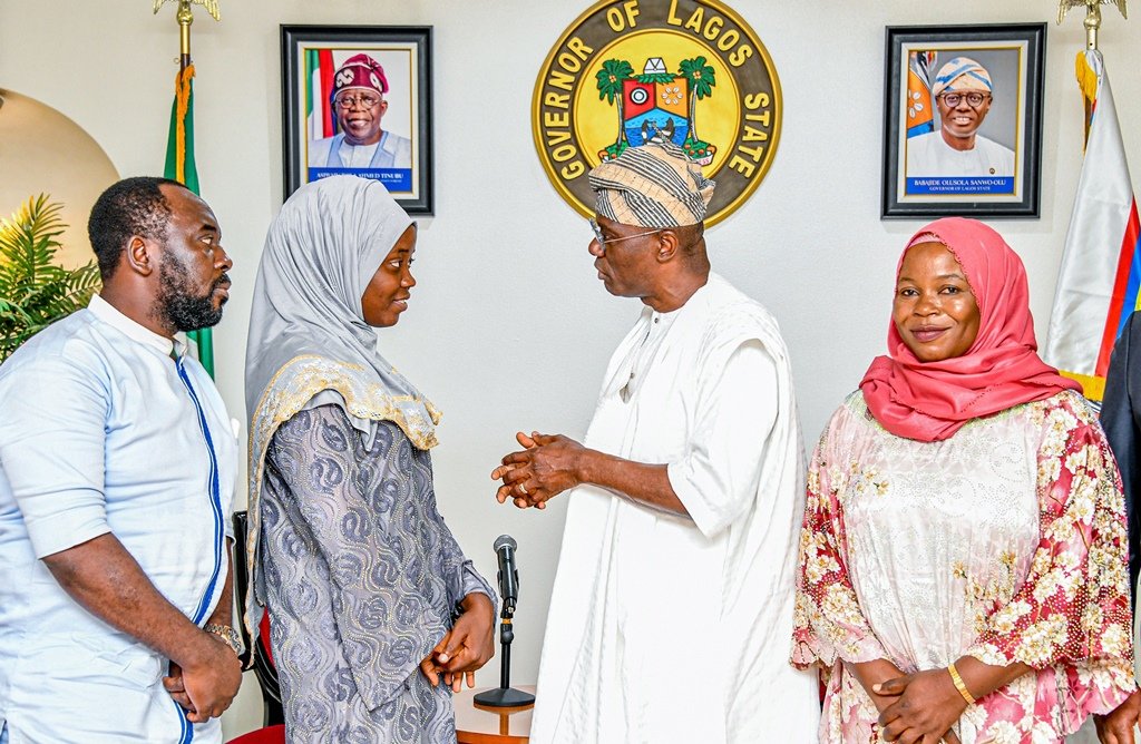 LASU's all-time best graduating student, Miss. Yusuf Aminat Imoitesemeh and Lagos State Governor Babajide Sanwo-Olu chat at his Marina office as her parents watched on
