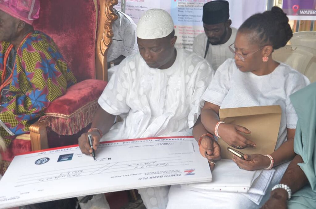 The Oloja-elect of Lagos, Abiola Kosoko, writing a N20,000 cheque