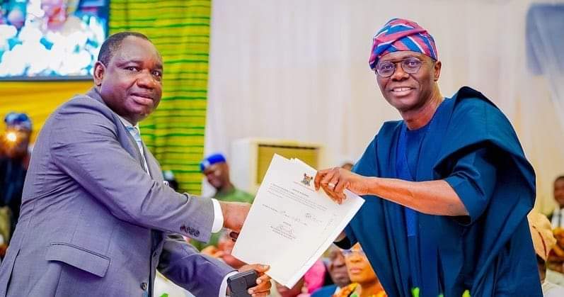 Lagos State Governor, Babajide Sanwo-Olu, presents a certificate to Commissioner for Information and Strategy, Gbenga Omotoso, after swearing him into office 