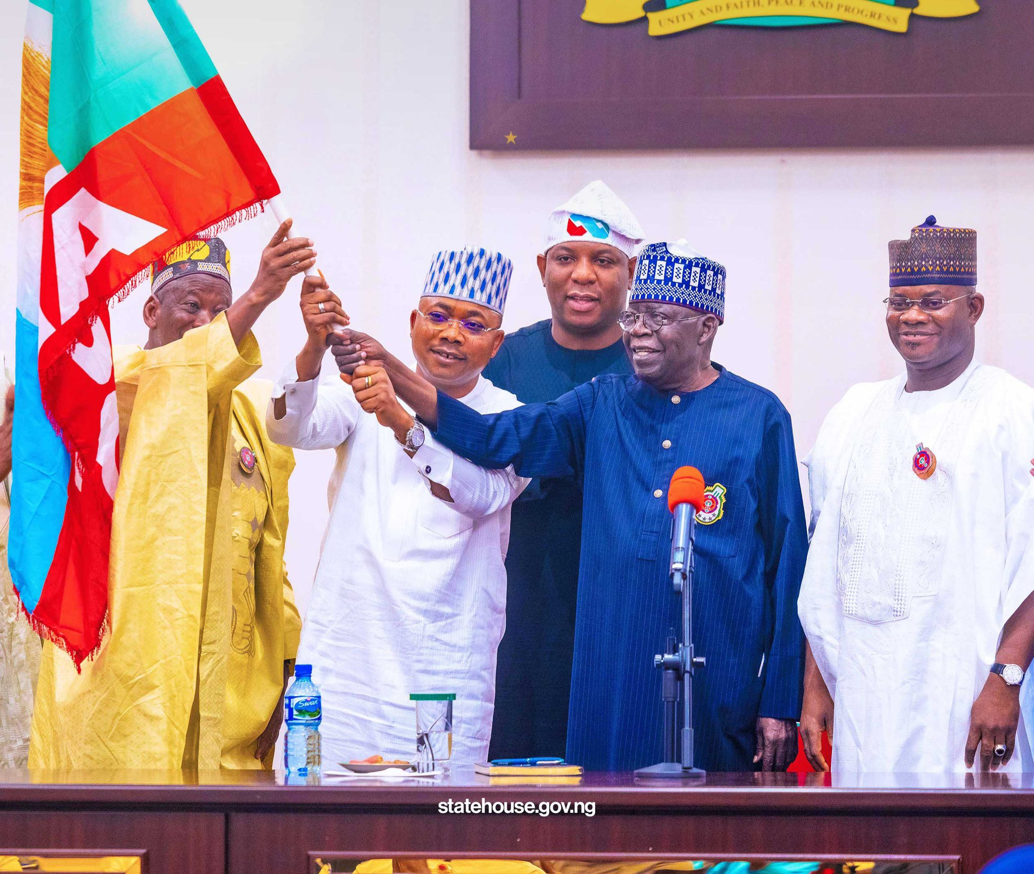 President Bola Tinubu hands the APC flag to the party's governorship candidate in Kogi State, Alhaji Ahmed Usman Ododo in company of current Kogi Governor, Yahaya Bello