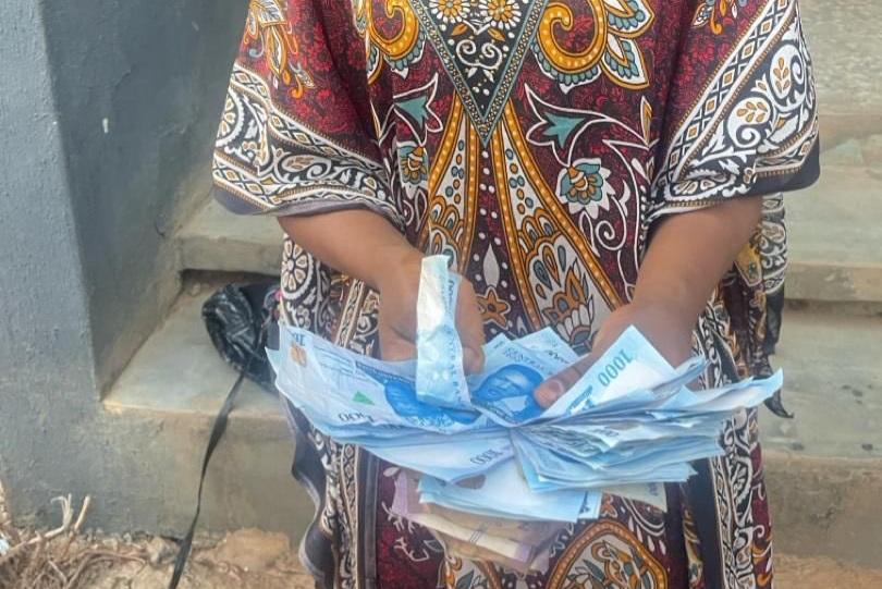 Linda Ihebinike holding the fake naira notes