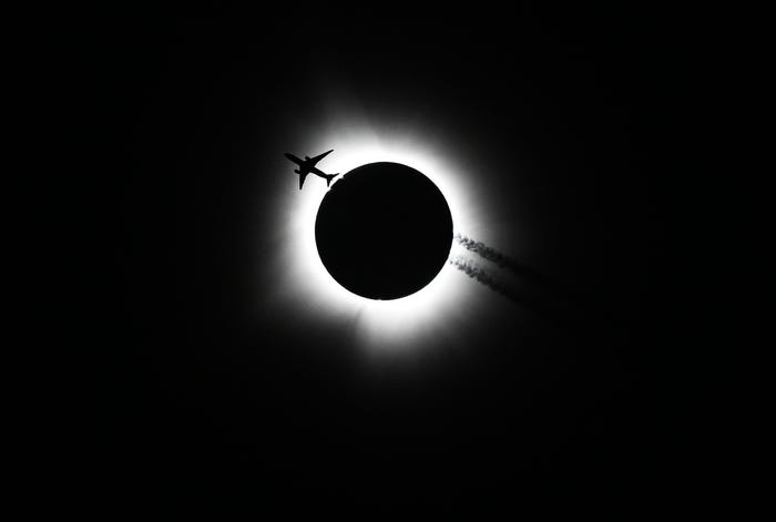 An airplane passes near the eclipse during the Hoosier Cosmic Celebration at Memorial Stadium on Monday, April 8, 2024.(Photo: Bobby Goddin/Herald-Times)