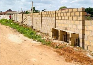 ongoing construction of a perimeter fence at UPE Primary School, Imokun.