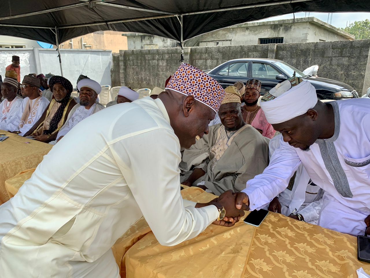 Hon. Hammed Seriki, son of the celebrant, Alhaji Seriki Bamu, exchanging pleasantries with a cleric at the birthday prayer programme