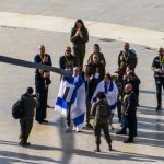 A released hostage, Ohad Ben Ami, draped in an Israeli flag gives a thumbs up after he arrives at Tel Aviv Sourasky Medical Center-Ichilov Hospital on Saturday.Alexi J. Rosenfeld / Getty Images