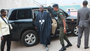 A police officer opening a car door for a popular pastor, Apostle Johnson Suleman