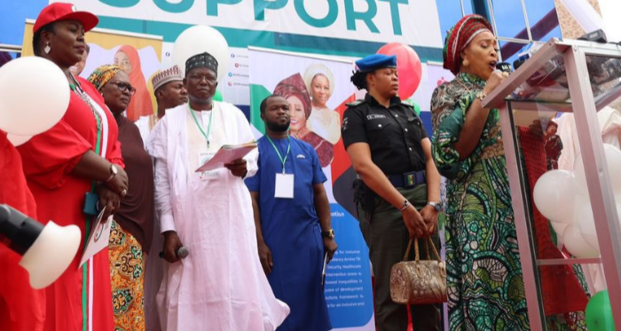 A policewoman carrying the bag of Titi Abubakar, the wife of former Vice President Atiku Abubakar at an event in Abuja in October 2022