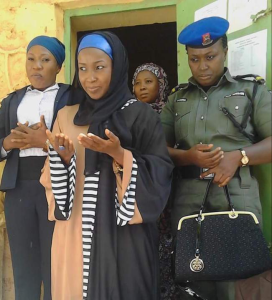 A policewoman holding the bag of Mariya Aminu Waziri, the wife of former Sokoto State governor, Aminu Tambuwal