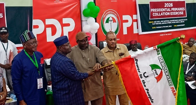 Sandy Onor being handed the PDP flag as the party's presidential candidate in the 2027 election