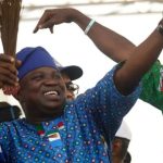 Former Lagos State Governor, Akinwunmi Ambode, in an APC-themed attire while holding a broom, the party's symbol