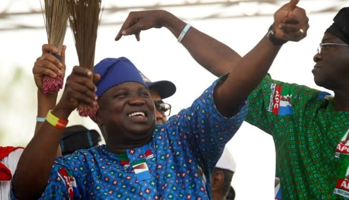 Former Lagos State Governor, Akinwunmi Ambode, in an APC-themed attire while holding a broom, the party's symbol