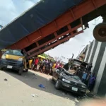 Six Escape Death as Container-Laden Trailer Falls from Anambra Bridge